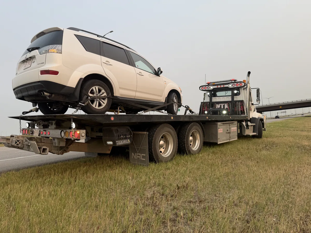 SUV loaded on a flat deck tow truck